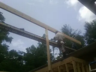 Carpenter setting a ridge beam over a new addition frame — Ice Dam Removal by Roofing Brothers in Oak Ridge
