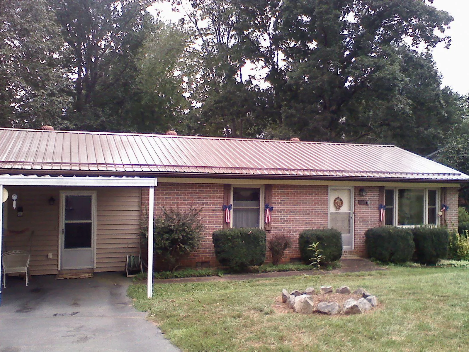 Bronze metal roof and carport on a brick ranch home — Roof Repair work by our crew in Oak Ridge